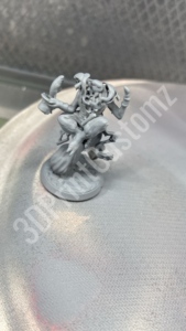 a small statue on a concrete surface 3DPrintCustomz Custom 3D Resin Printing